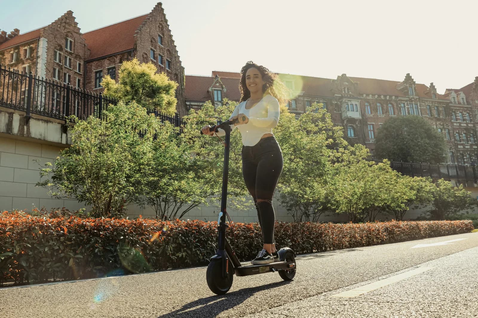 A woman riding an electric scooter down a street